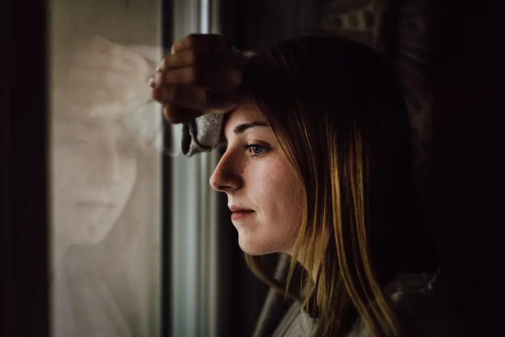 Young sad woman staring out of window