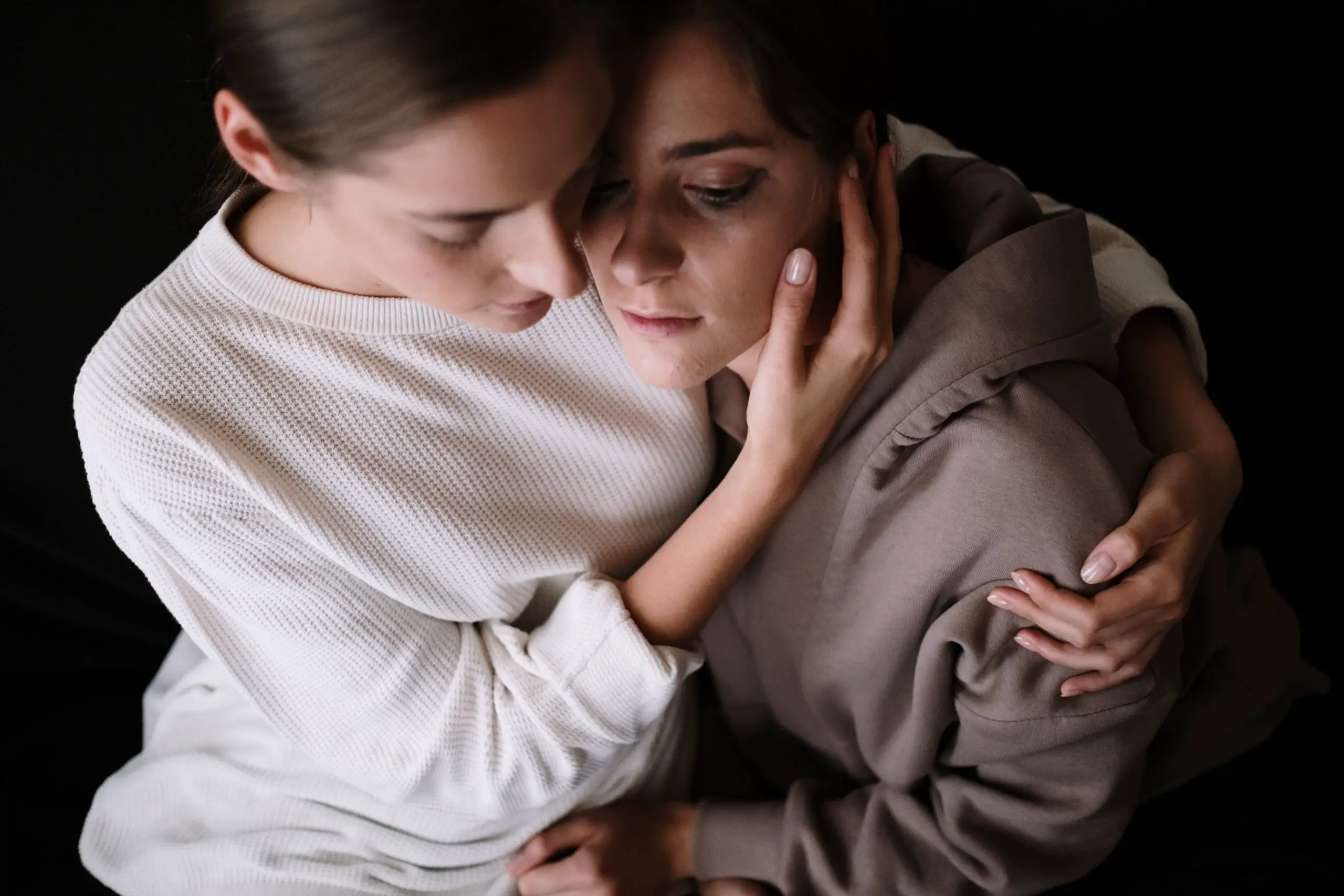 One woman consoling and hugging her girlfriend